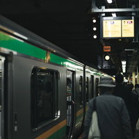駅のホームに停まる電車と乗客の写真