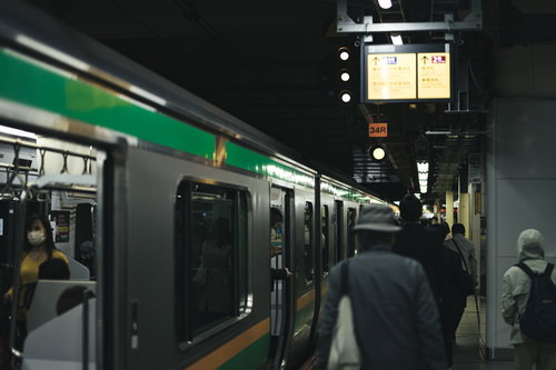 駅のホームに停まる電車と乗客