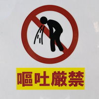 嘔吐厳禁と書かれた赤い禁止マークの警告標識の写真