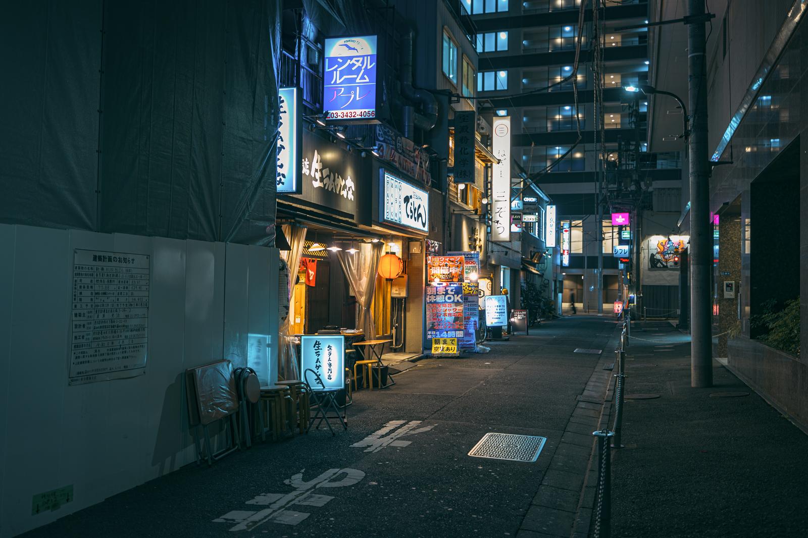 新橋の路地裏に居酒屋の看板と暖色のネオン灯が点灯する夜景
