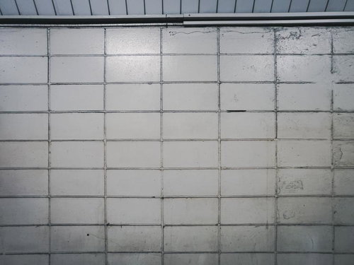 古い駅の白い壁のテクスチャー 劣化したタイル壁