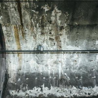 雨漏り跡がひどい地下鉄駅の老朽化した壁面のコンクリート損傷の写真