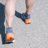 ランニングシューズを履いたアスリートの鍛えられた足元の写真