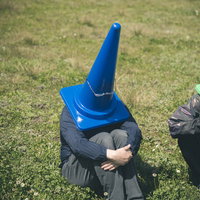 闇落ちカラーコーン青で体育座りする人の落ち込み表現の写真