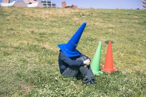 戦いに敗れた仲間を想うリーダー、青いカラーコーンを被り河川敷で佇む