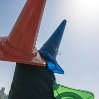青空の下でカラーコーンを被った怪人△コーンマンの写真