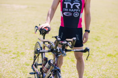 ロードバイクに手を添えるトライアスリート
