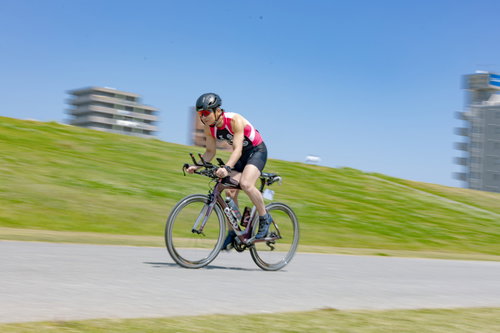 ヘルメット着用で自転車を走行するトライアスリートの男性