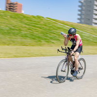 トライアスロン競技で自転車走行する選手の力強い走りの写真