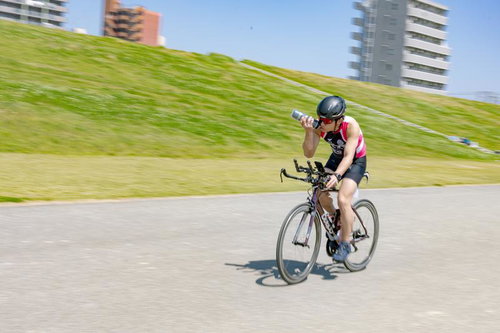 トライアスロン競技で自転車走行する選手の力強い走り