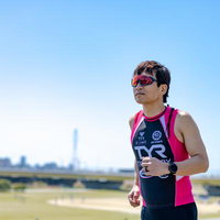河川敷を走るトライアスロン選手の写真