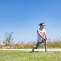 ランニング前に準備体操をする男性の写真