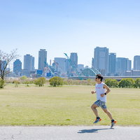 淀川河川公園西中島地区の河川敷でトレーニングランニングする男性の写真