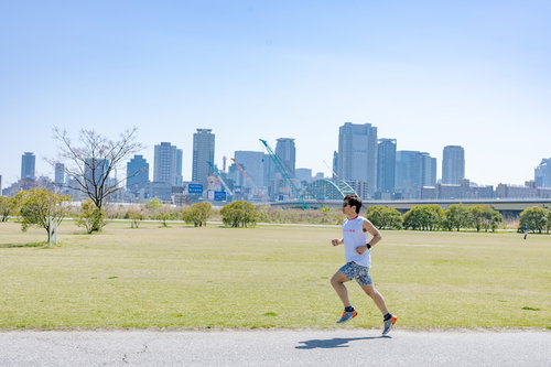 淀川河川公園西中島地区の河川敷でトレーニングランニングする男性