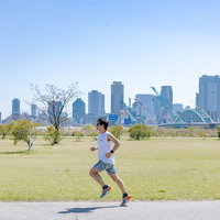 河川敷で軽快に走るトライアスリートの男性の写真