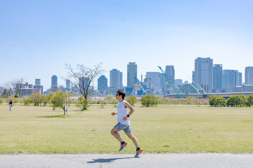 河川敷で軽快に走るトライアスリートの男性