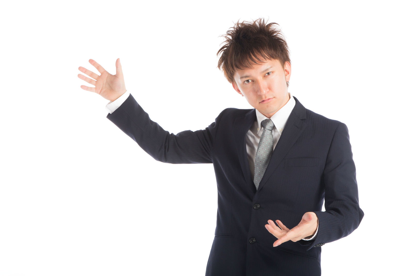 紺色スーツを着た男性が左手を上げて説明するジェスチャーを示している［モデル：鈴木秀］