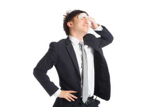 真夏日のスーツで暑くてツライ日中、汗をぬぐう男性会社員