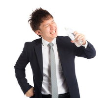 「プハー！」暑さの中、水分補給をする会社員の写真
