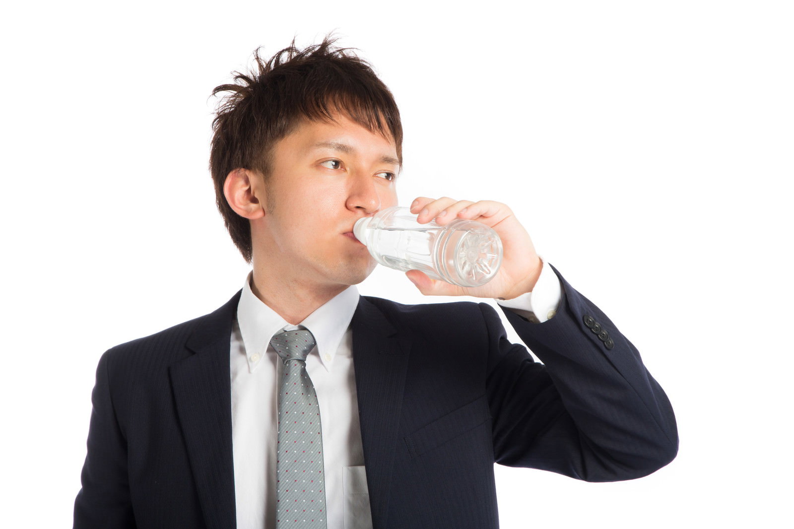 紺スーツのビジネスマンがグラスで水を飲んでいる［モデル：鈴木秀］
