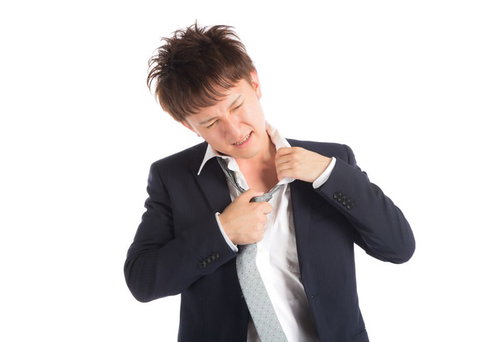 真夏にスーツは暑すぎる、ネクタイを緩める男性