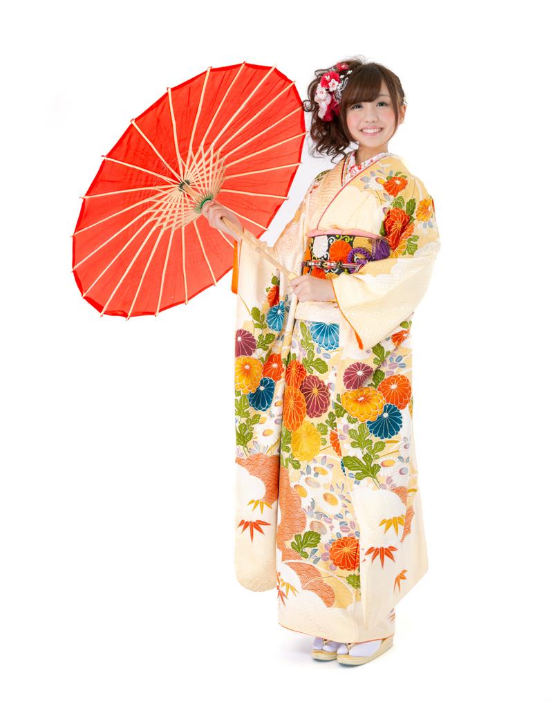 赤い和傘を持ち、花柄の振袖を着た女性が笑顔で立っている［モデル：河村友歌］