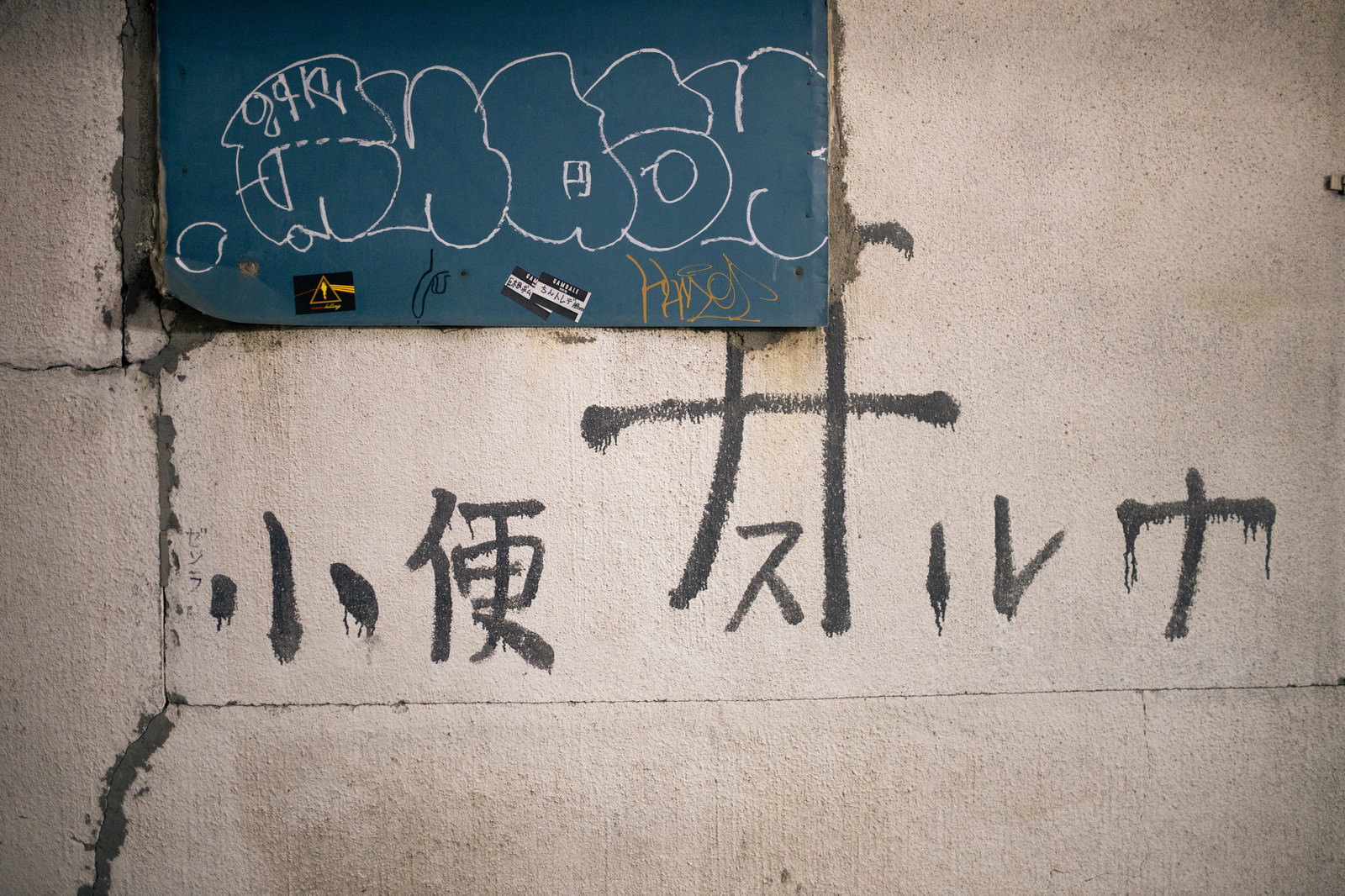 野毛横丁の壁に描かれた黒と白のスプレーペイントの落書き