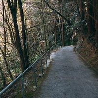 備中鐘乳穴に向かう山道の坂道を歩く観光客向けハイキングルートの写真