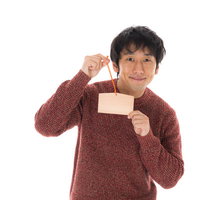 絵馬を手に取る祈願男子の正月参詣と初詣の願い事の写真