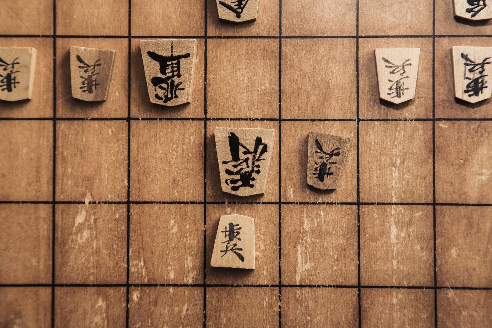 将棋盤で歩の駒が王将に王手をかけている場面