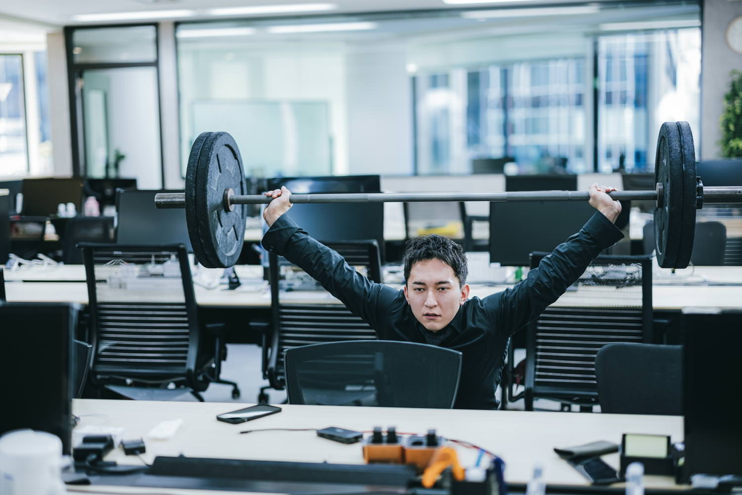 朝一のオフィスでスクワットスナッチをする代表の姿の写真素材