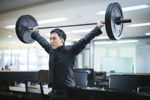 社内で重量挙げに挑むマッスル社長