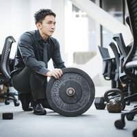 オフィスジムでバーベルの重さを考える経営者の写真