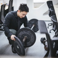 オフィスでバーベルの重りを調整する経営者の写真