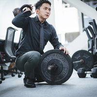 鋼鉄製のケトルベルを持つ男性経営者がオフィスでトレーニングの写真