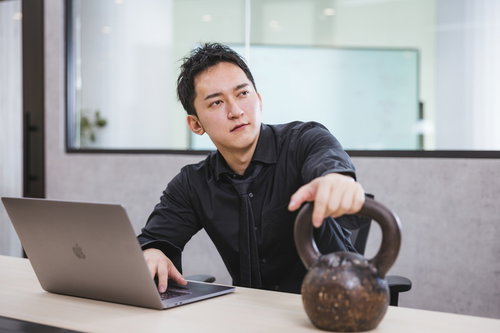 業績が低迷している部署の報告を受ける度にケトルベルに手を乗せる経営者