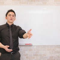 ホワイトボードの前でプレゼンする経営者の説得力あるビジネス講演の写真