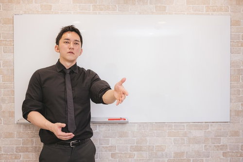 ホワイトボードの前でプレゼンする経営者の説得力あるビジネス講演