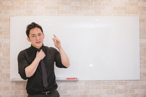 ホワイトボードの前で熱心に企画の趣旨を伝える男性