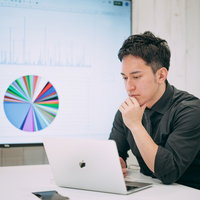 グラフデータを見ながら今後の経営方針について考える社長の写真