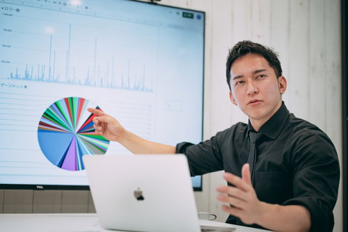 経営会議中にグラフ資料を指す弊社代表の説明風景