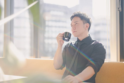 コーヒータイム中でもイケてる経営者、高層ビルの窓辺での一息