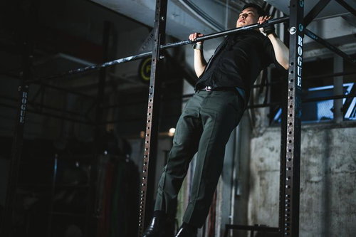 スーツ姿でジムの懸垂バーを使った上半身のトレーニング