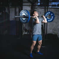 ジムで重量バーベルを担ぎ上げる筋力アップ男性リフターの写真