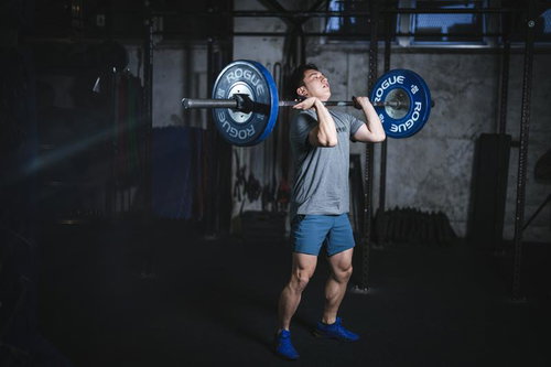 ジムで重量バーベルを担ぎ上げる筋力アップ男性リフター