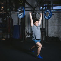 クリーンアンドジャークをスプリットスタンスで行う男性の写真