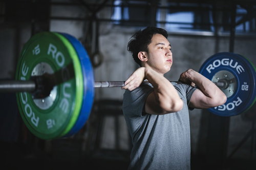 バーベルを肩に担いでトレーニングする男性