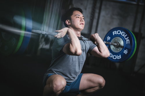 バーベルを担いでスクワットするウエイトリフティングのトレーニング