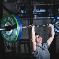 重いバーベルを両手で持ち上げるウエイトリフティングの男性の写真