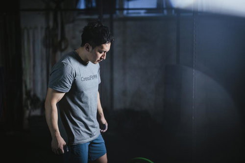 ジムでバーベルに集中して目線を落とす男性のトレーニング姿